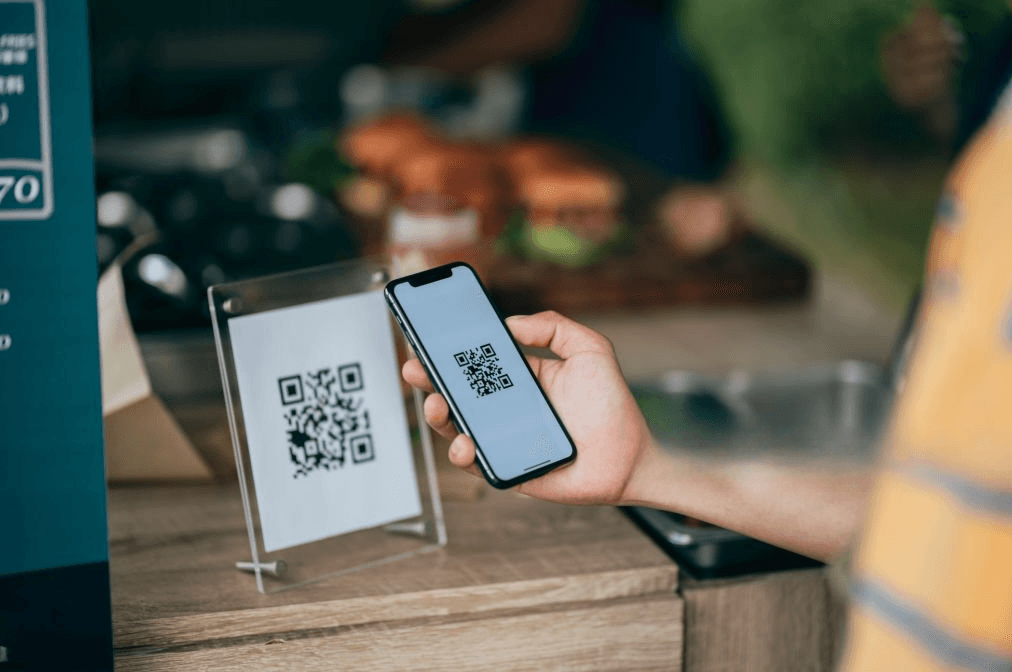 homem lendo qr code preto e branco em um estabelecimento