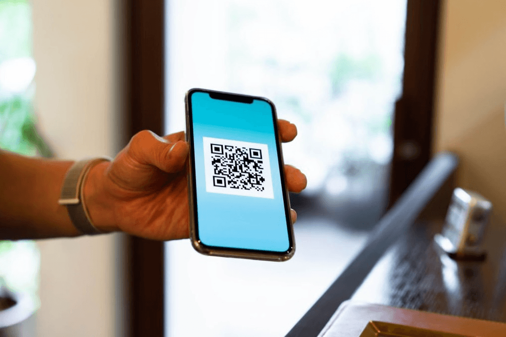 homem mostrando qr code no tamanho ideal em um celular com um fundo azul